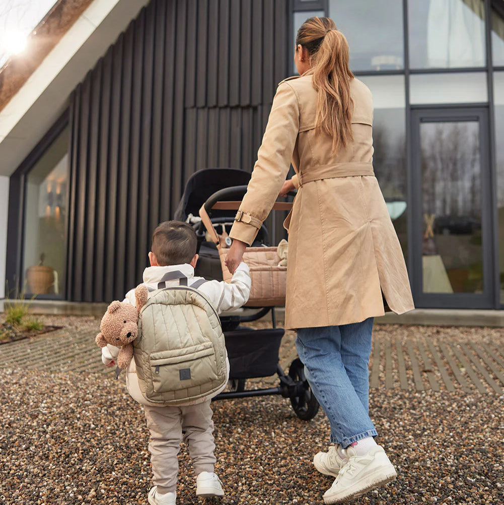 Kind met Jollein puffed rugzak Olive Green naast moeder met kinderwagen